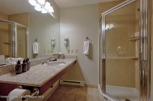 a bathroom with a granite countertop shower a sink and vanity