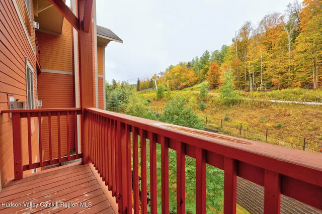 a view of a balcony with wooden floor & fence