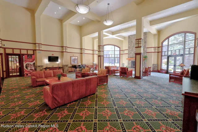 a living room with furniture a chandelier and a rug