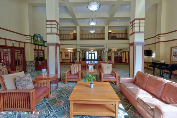 a living room with furniture a table and kitchen view