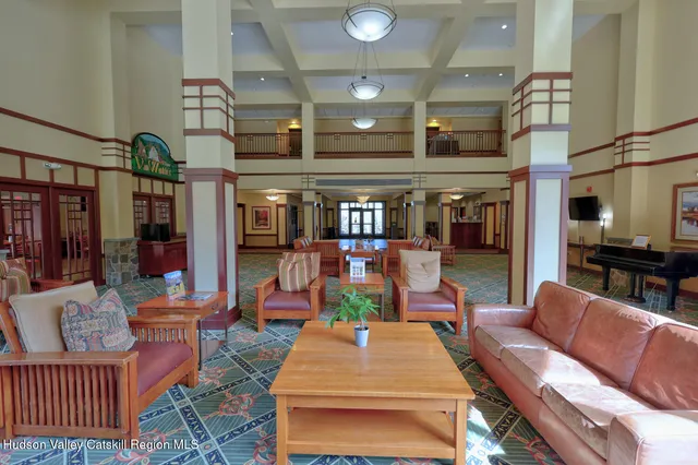 a living room with furniture a table and kitchen view
