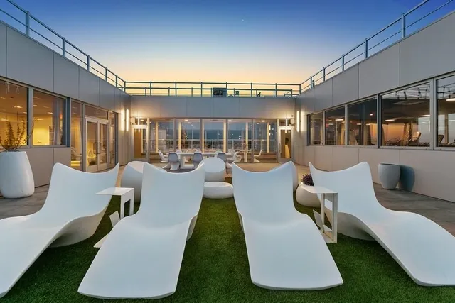 a view of a patio with couches dining table and chairs with wooden floor