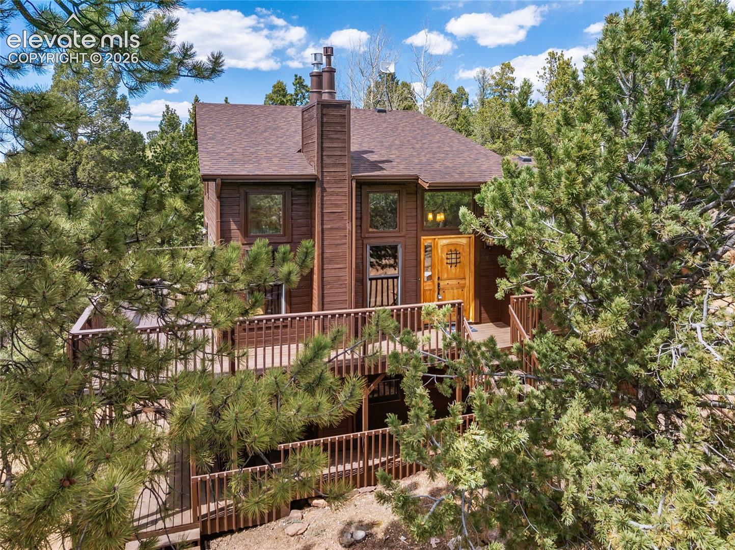 Home sits among mature pine trees in a peaceful setting.