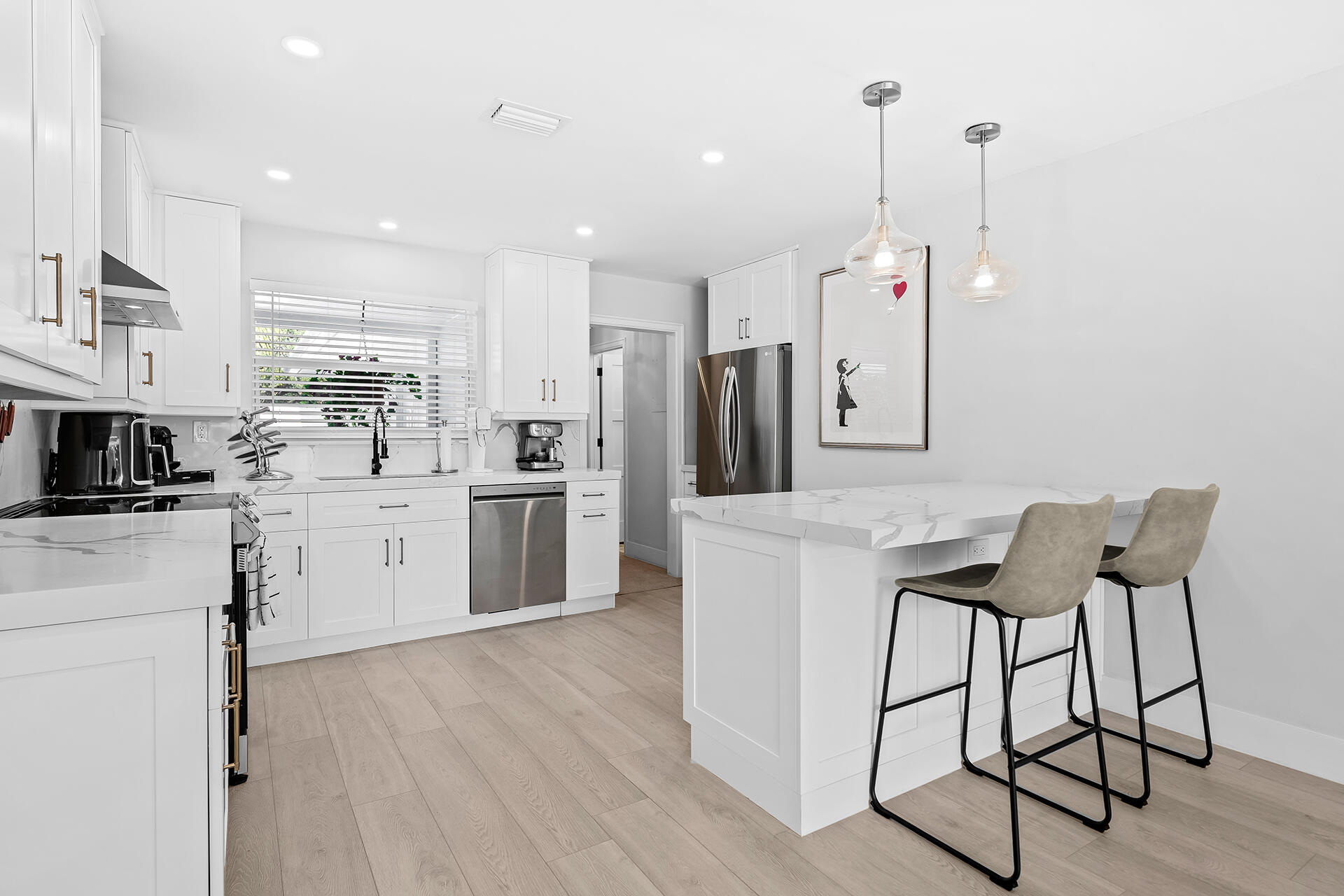 698 West Camino Boca Raton, FL 33486 - Photo 8 of 30 a kitchen with white cabinets and stainless steel appliances