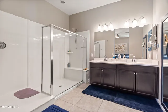 a bathroom with a double vanity sink mirror and shower