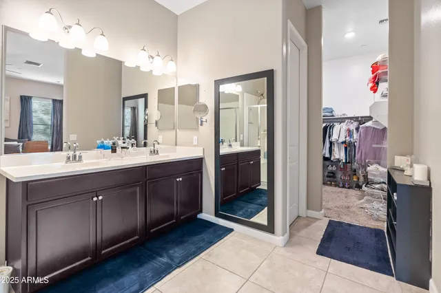 a spacious bathroom with a double vanity sink a mirror and shower