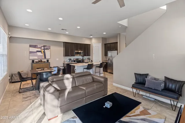 a living room with furniture a flat screen tv and kitchen view
