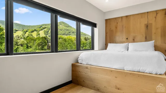 a large bed sitting in a bedroom next to a window