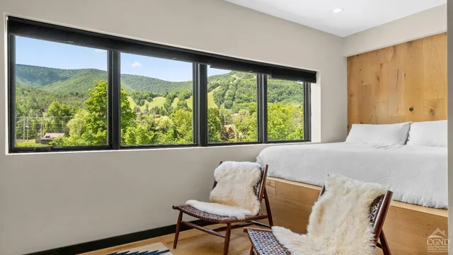 a bedroom with a bed and painting on the wall