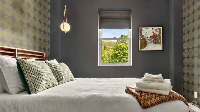 a bedroom with two beds and a painting on the wall