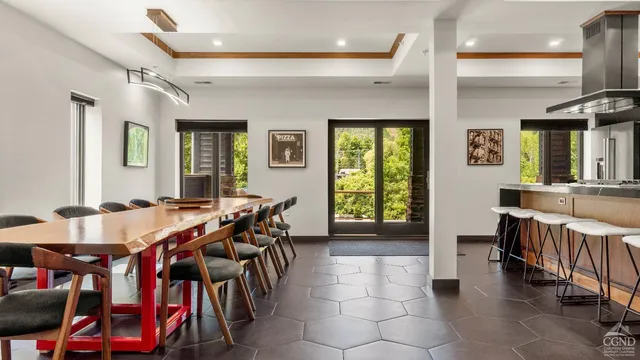 a large dining hall with stainless steel appliances granite countertop a stove and a dining table with kitchen view