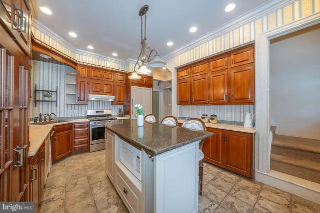 a kitchen with stainless steel appliances granite countertop a sink stove and refrigerator