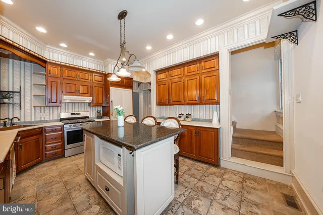 a kitchen with stainless steel appliances granite countertop a sink and stove