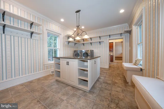 a kitchen with white cabinets and window