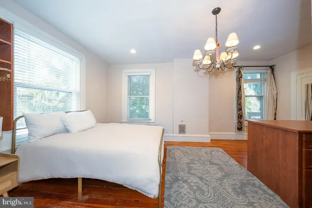 a bedroom with a large bed and a chandelier