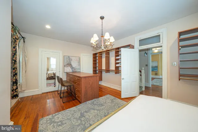 a dining room with wooden floor a chandelier a wooden table and chairs