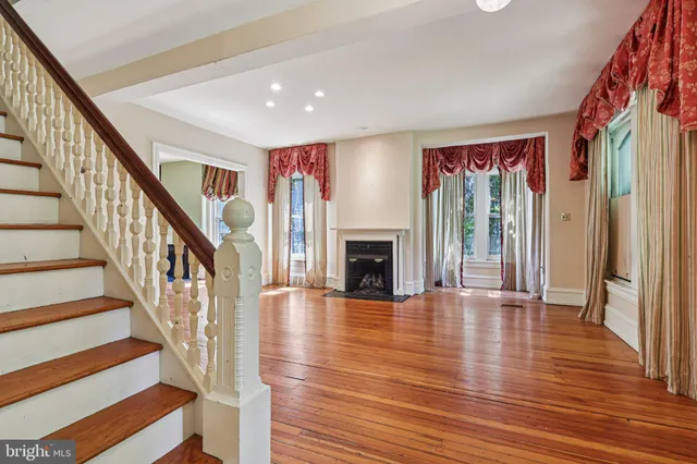 a view of an entryway with wooden floor fireplace and a window