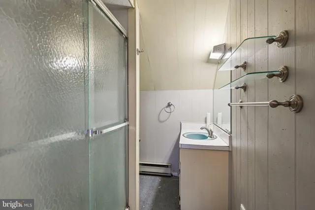 a bathroom with a sink vanity and shower