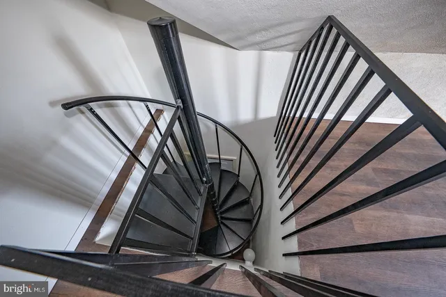 a view of staircase with wooden floor and a rug
