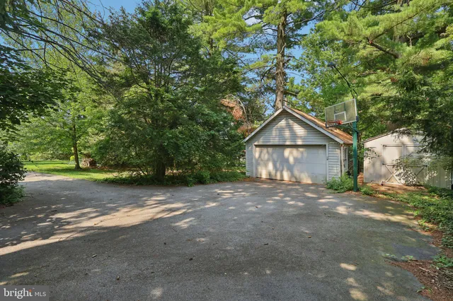a view of a house with a yard and large tree
