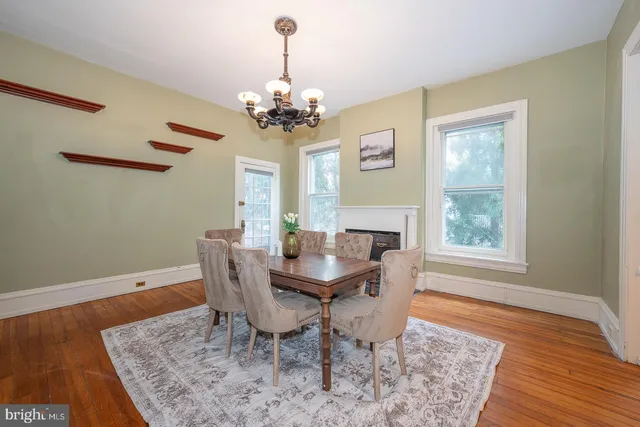 a view of a dining room with furniture a chandelier and wooden floor