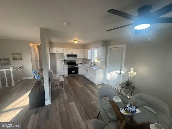 a living room with furniture and a dining table with kitchen view