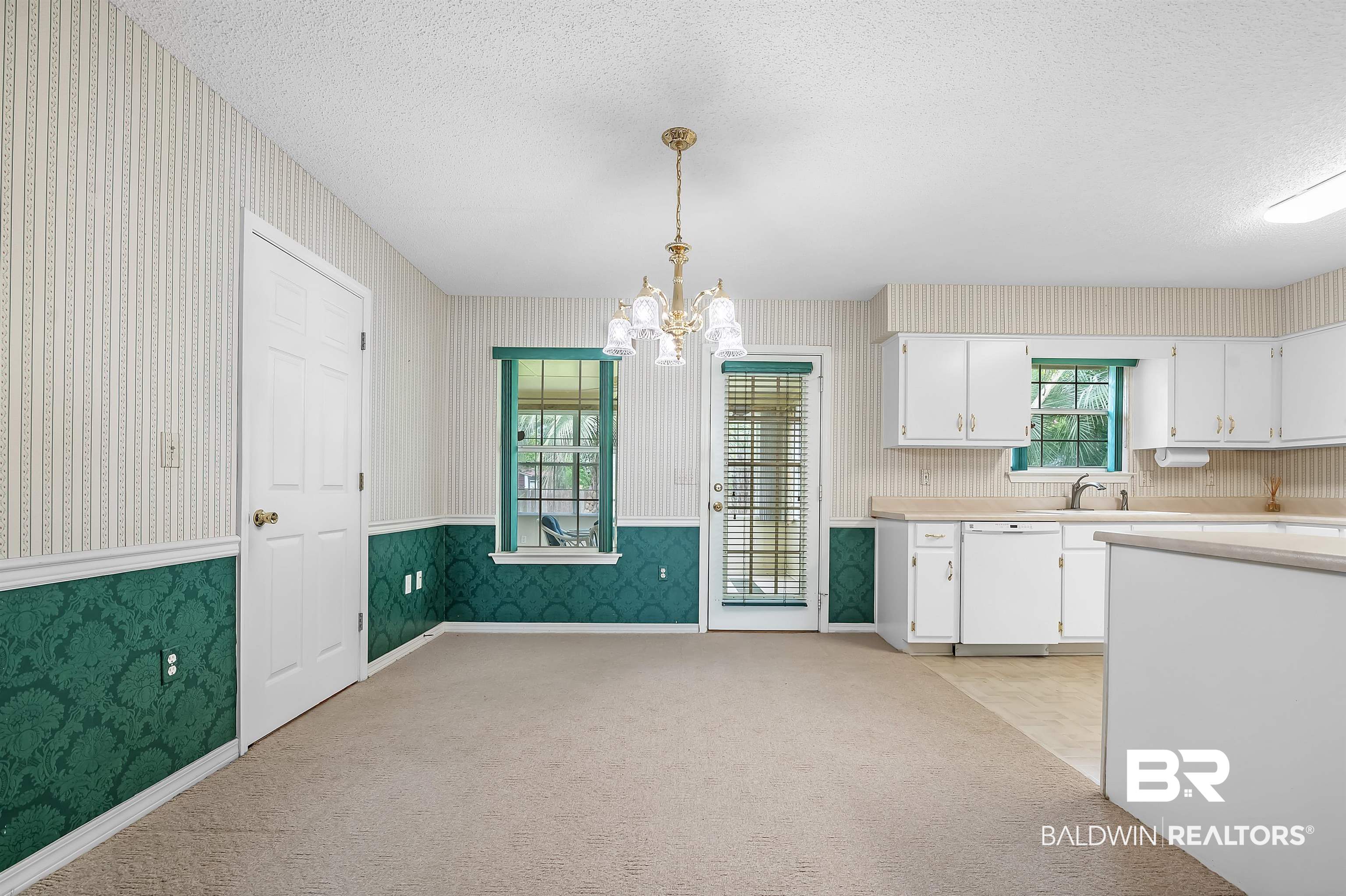 1502 Mulberry Lane Foley, AL 36535 - Photo 16 of 45 Kitchen featuring white cabinetry, light carpet, a notable chandelier, and white dishwasher