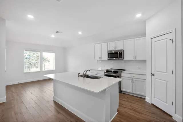 a kitchen with stainless steel appliances granite countertop a sink stove and wooden floor