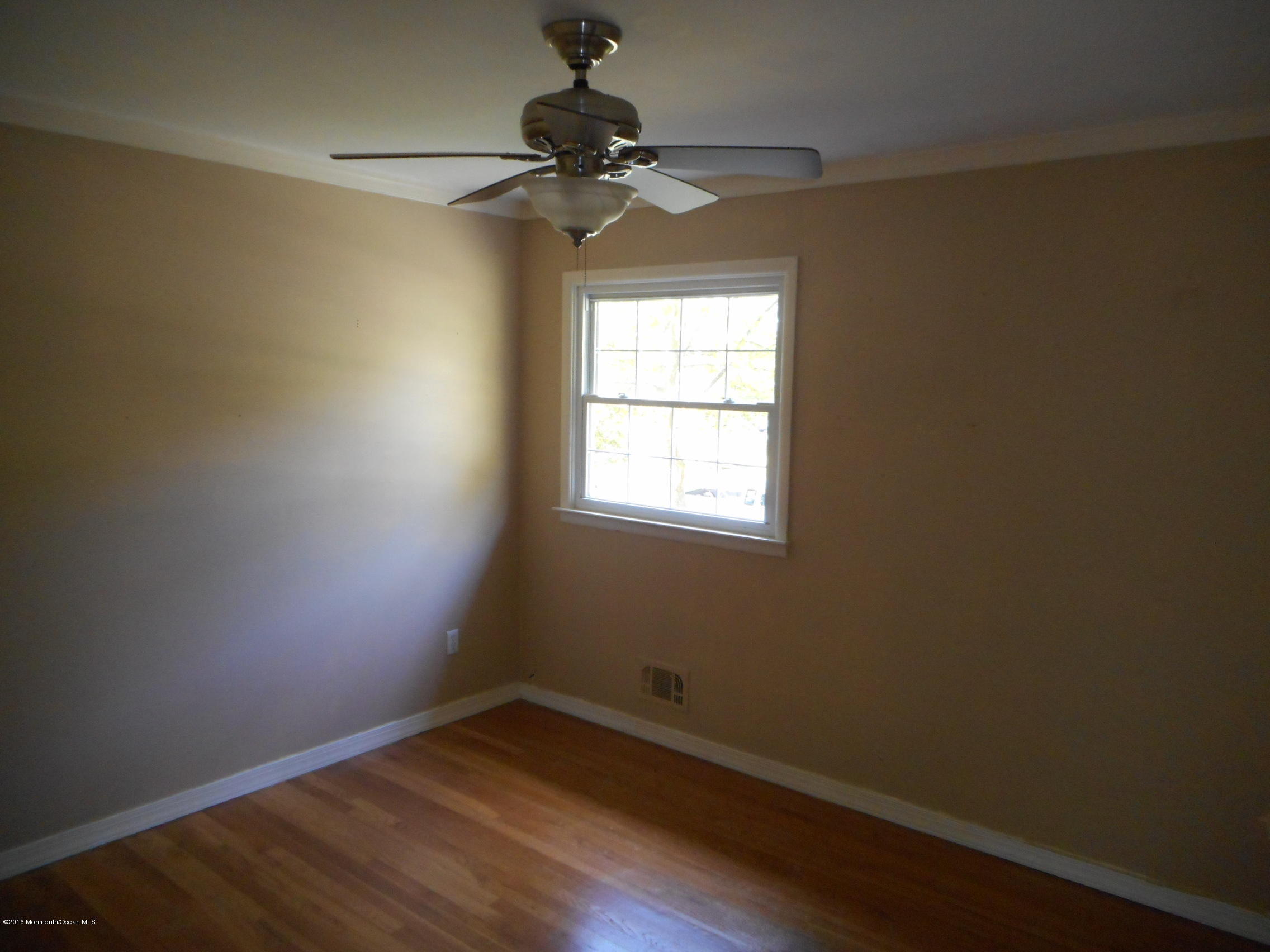 104 Bar Harbor Road Freehold, NJ 07728 - Photo 6 of 18 a view of an empty room with wooden floor and a window