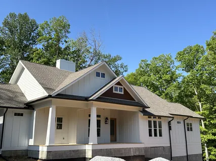 a view of a white house next to a yard