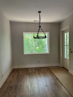 an empty room with window and wooden floor