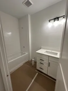 a bathroom with a tub sink and vanity