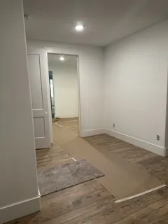an empty room with wooden floor and mirror