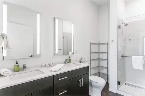 a bathroom with a granite countertop sink toilet and shower