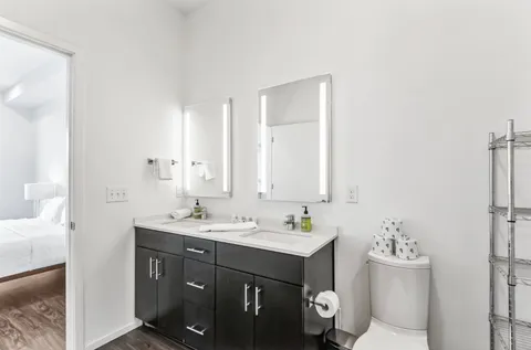 a bathroom with a sink vanity mirror and toilet