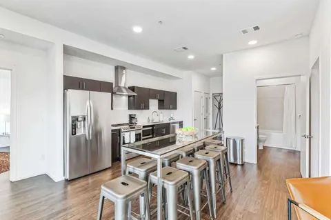 a kitchen with stainless steel appliances a refrigerator stove microwave and wooden floor