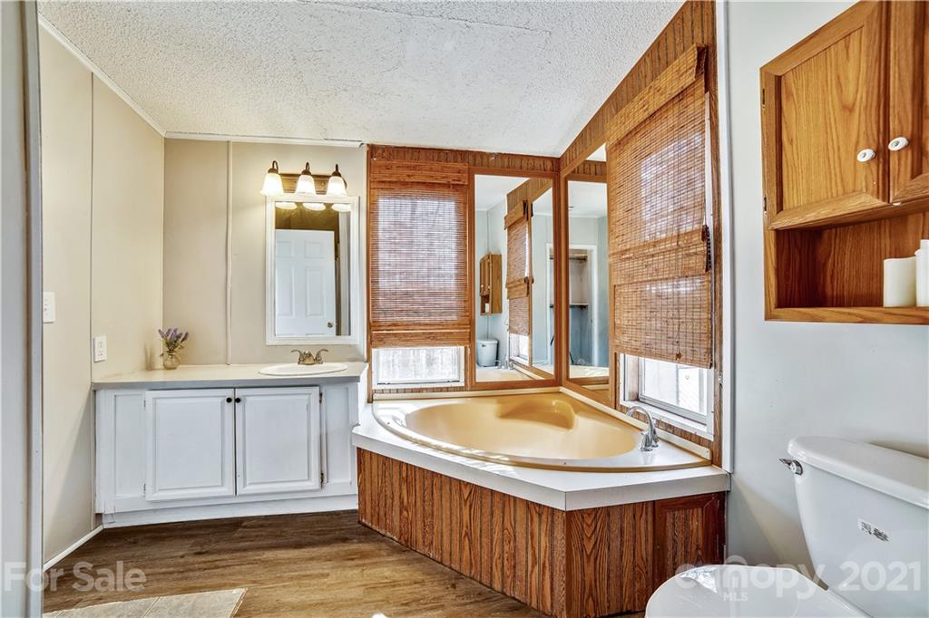 404 Rutledge Road Mount Holly, NC 28120 - Photo 22 of 40 a bathroom with a tub a sink and a window