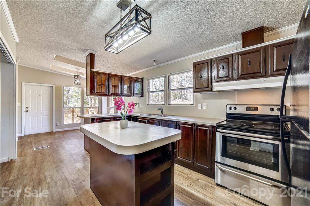 404 Rutledge Road Mount Holly, NC 28120 - Photo 5 of 40 a kitchen with kitchen island a stove a sink and a microwave