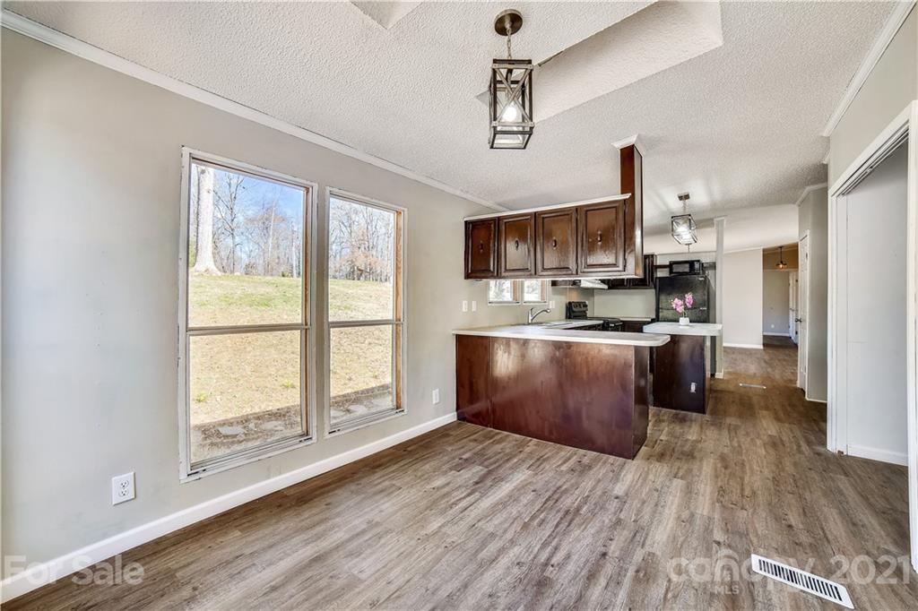 404 Rutledge Road Mount Holly, NC 28120 - Photo 7 of 40 a large kitchen with stainless steel appliances granite countertop a stove a sink dishwasher a microwave oven and a refrigerator with wooden floor