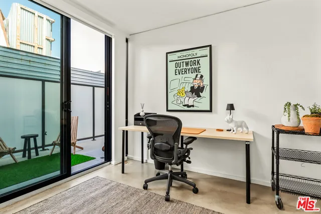 a view of a workspace with furniture and a window