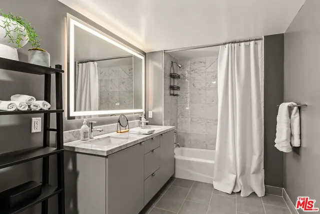 a bathroom with a double vanity sink a mirror and a shower