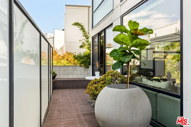 a dining room filled with furniture and a potted plant