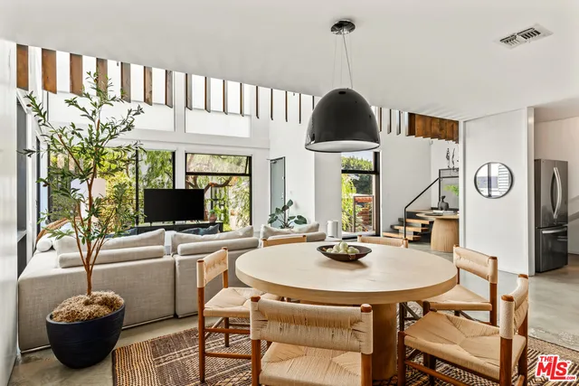 a living room with furniture a chandelier and a flat screen tv