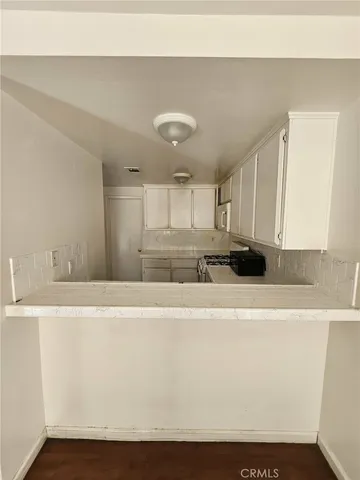 a kitchen with a stove sink and cabinets