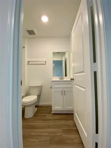 a bathroom with a toilet a sink a vanity and mirror
