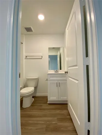 a bathroom with a toilet a sink a vanity and mirror