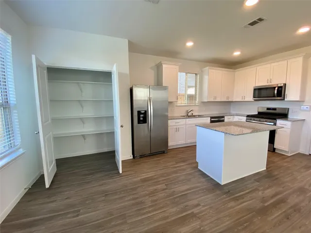 a kitchen with stainless steel appliances a refrigerator and a stove top oven