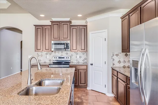 a kitchen with stainless steel appliances granite countertop a refrigerator and a sink