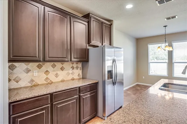 a kitchen with stainless steel appliances granite countertop a refrigerator and a sink
