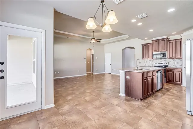 a open kitchen with a stove a refrigerator a sink dishwasher and a oven with cabinets